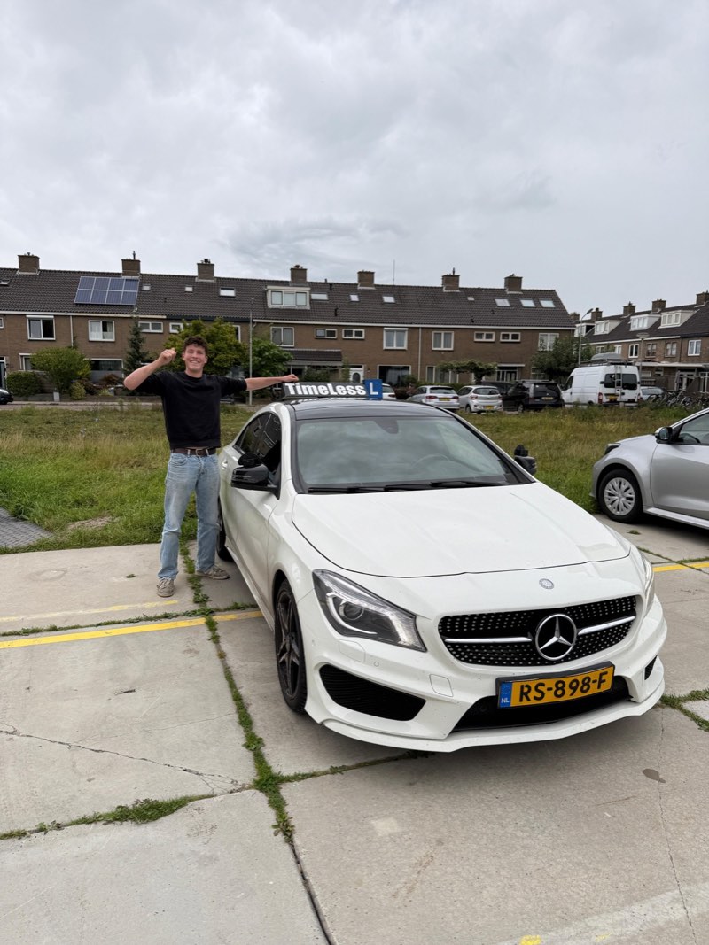 Geslaagde leerling naast de TimeLess-lesauto